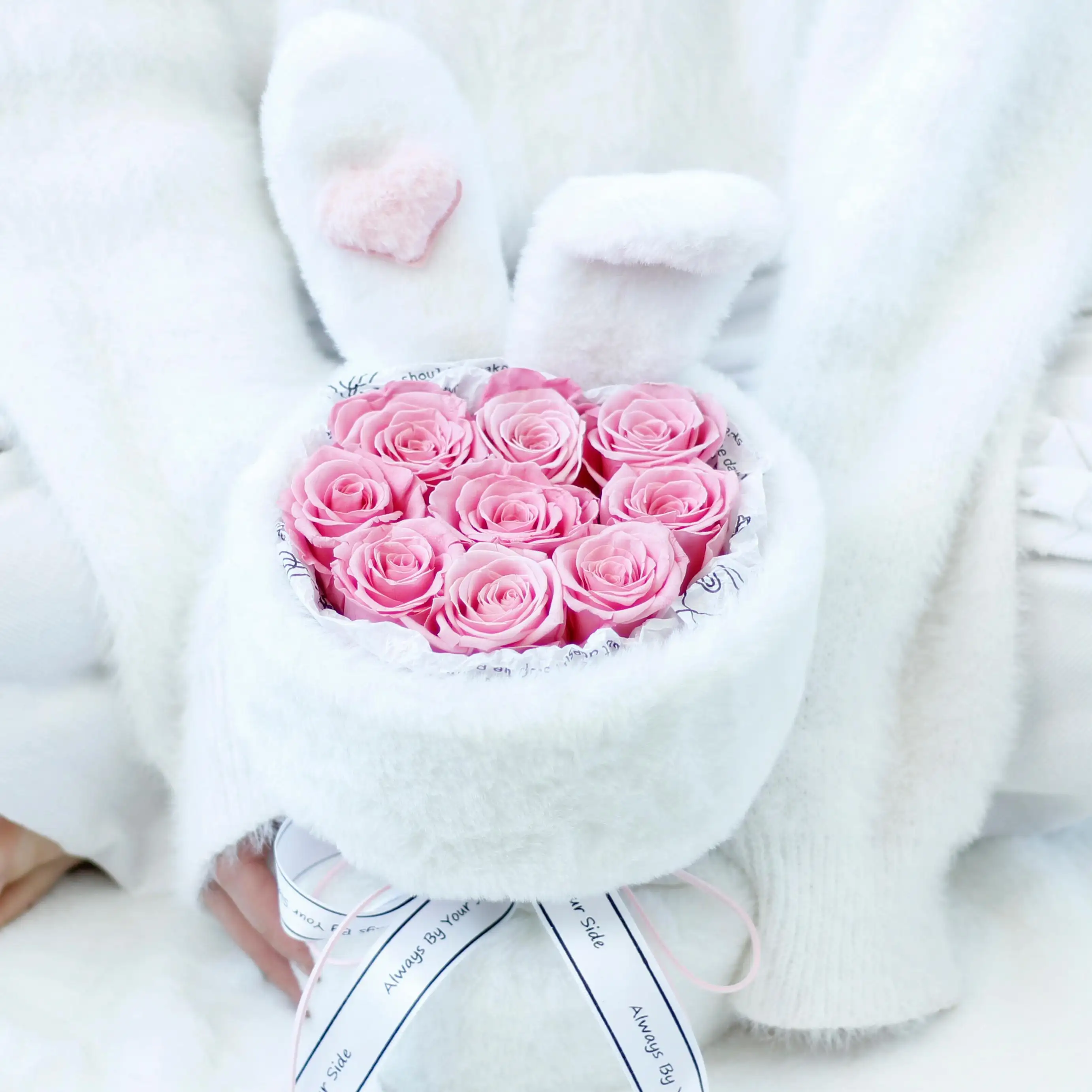 Heart-shaped arrangement of pink roses in a white box with a soft focus background