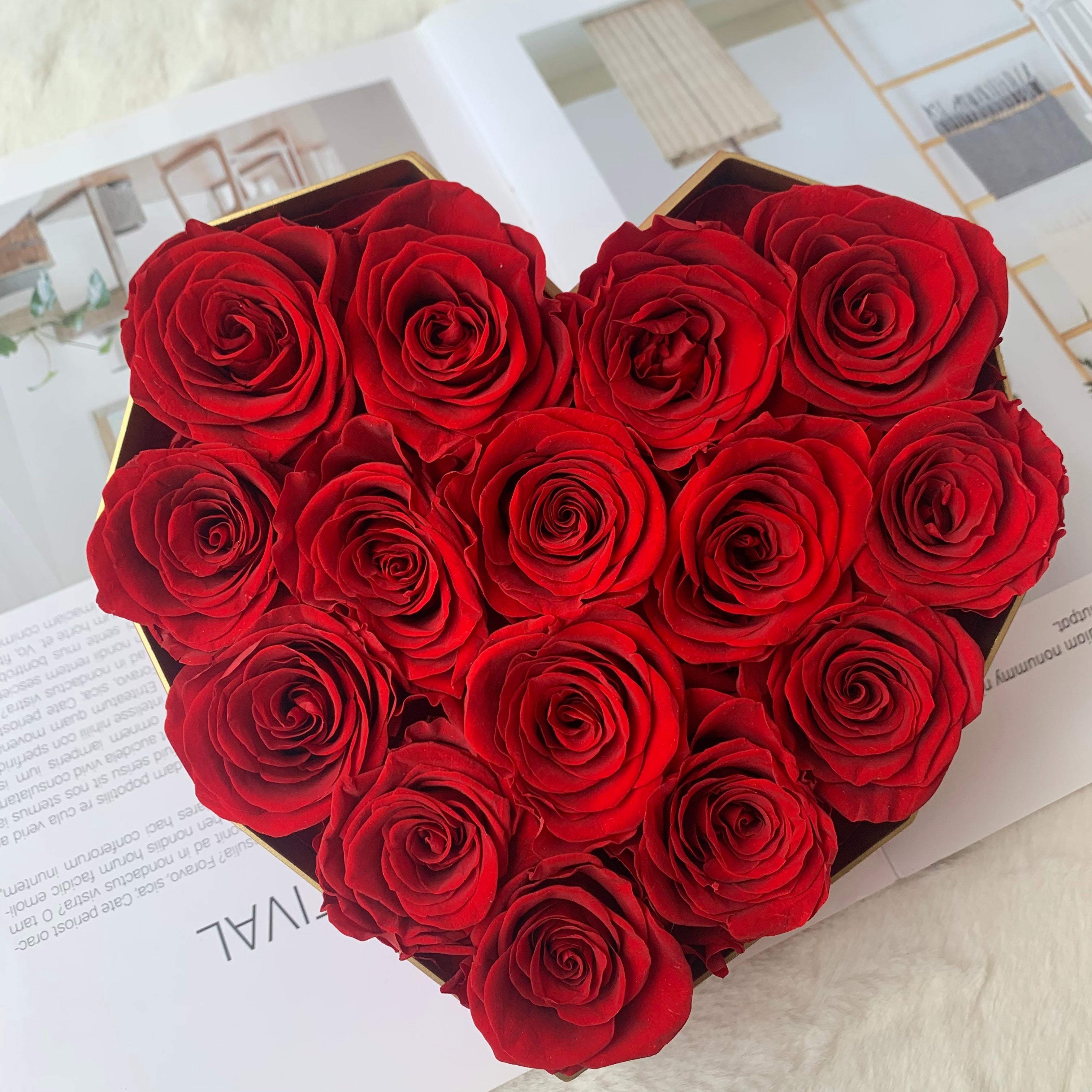 Heart-shaped box of red roses on a light surface