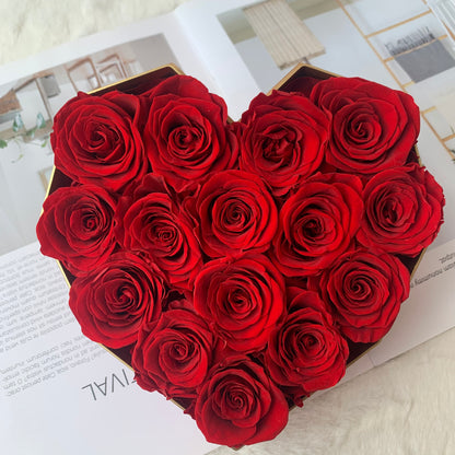 Heart-shaped box of red roses on a light surface
